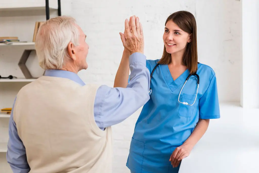 caregiver high fiving with old man